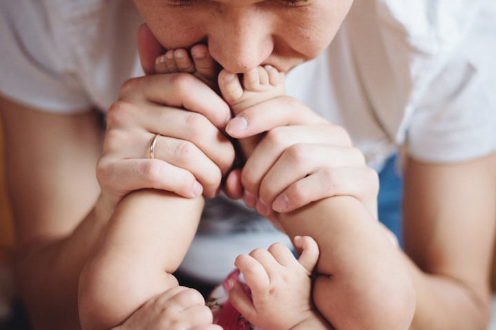 Parent kisses baby's feet