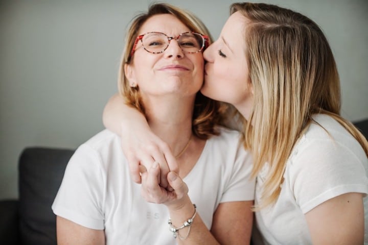 mother kisses her grown daughter