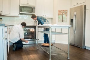 two men inspect a possibly broken stove