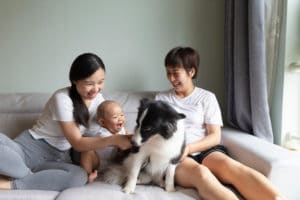 Family sitting on the couch with baby and dog