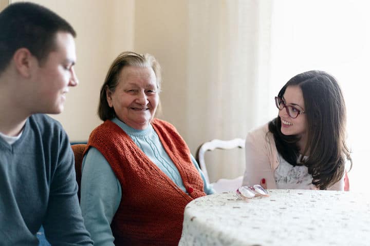 Two adult grandchildren spend time caring for their elderly grandma