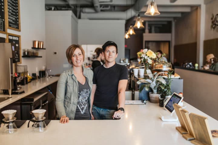 Rebecca and Phil stand together in their classy coffeehouse