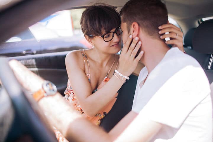 A young couple stare lovingly into each other's eyes while in the car