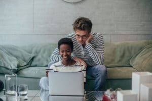 Trendy young couple shop on their laptop together