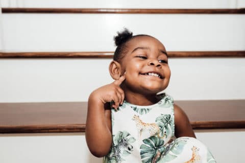 Black toddler girl smiling on the stairs