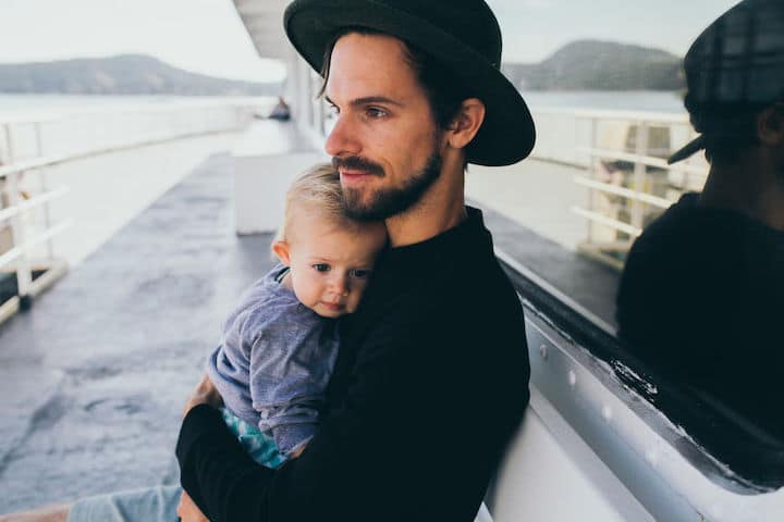 Father cuddles his tiny son on a small day-trip boat