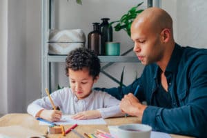 Father lovingly helps his son color