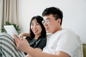 Young couple using digital tablet together in bed