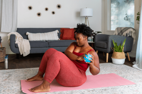 Woman uses exercise ball to do a crunch.