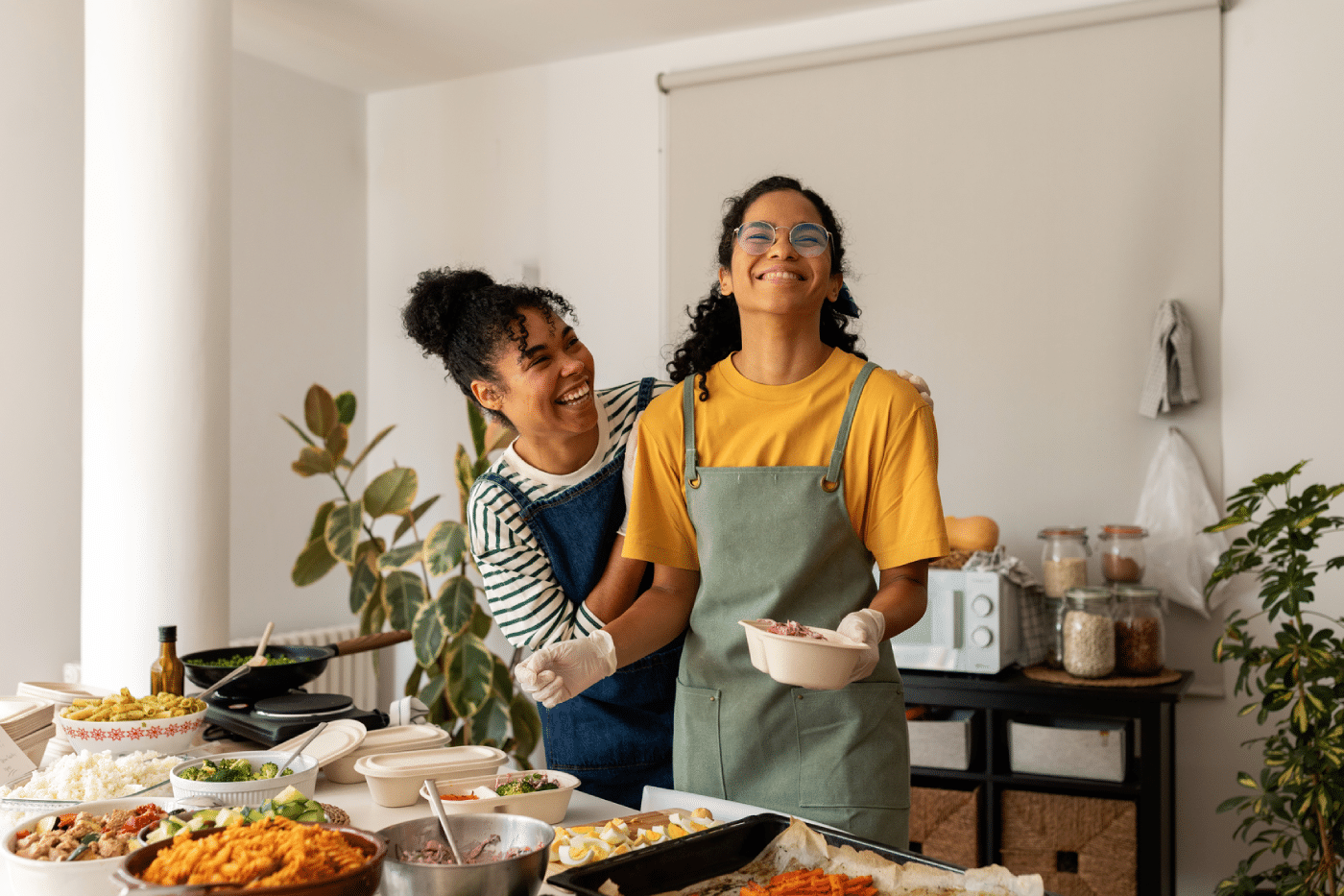 Female cooks having fun making different dishes prepared to serve at home