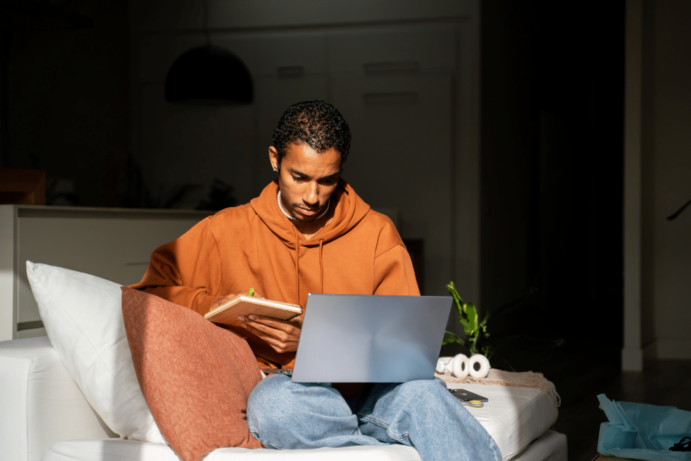 Man using laptop while sitting on couch at home. He is looking at the screen. he works from home and watches a movie online